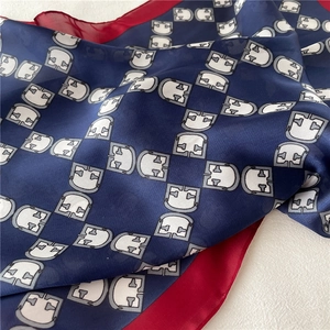 Detailed view of 70cm navy silk square scarf with red border and geometric pattern