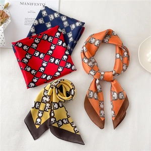 Close-up of geometric chain print scarves in navy, red, yellow and orange tones
