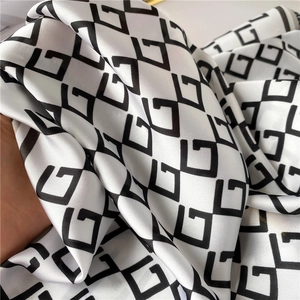 Close-up of a 70cm silk-like square scarf with black and white geometric G patterns
