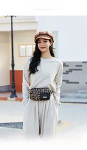 Outdoor model show of a stylish leopard print running waist bag with gold logo detail