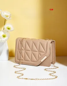 Close-up of beige quilted crossbody bag with golden chain strap and magnetic lock