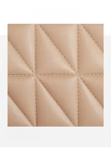 Macro shot of geometric quilted pattern on khaki crossbody handbag with adjustable strap
