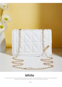 Detail of white quilted crossbody bag with gold chain strap and geometric pattern