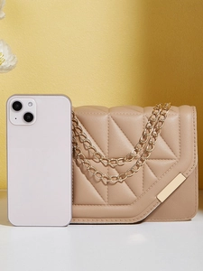 Quilted beige crossbody bag with gold chain and magnetic closure with phone for scale