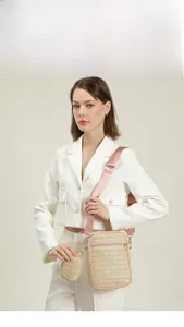 Borsa a tracolla in paglia con cinturino rosa e mini portamonete indossata