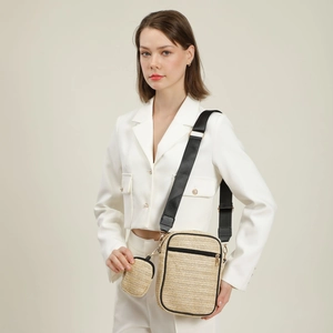 Set borsa a tracolla in paglia con finiture nere e portamonete esposta su modella