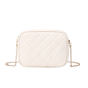 Macro detail of beige quilted PU leather camera bag with golden metal chain strap