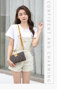 Detailed view of monogram print crossbody bag with yellow strap on female model
