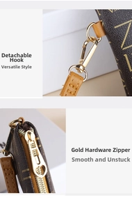 Detail of a brown leather pouch with gold-tone hardware zipper and detachable metal hook