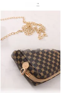 Détail du sac vintage marron à pois avec bandoulière chaîne dorée et fermeture éclair