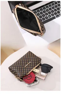 Vue intérieure d'un sac bandoulière vintage montrant le rangement pour mobiles et accessoires