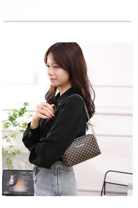 Sac bandoulière à carreaux marron foncé avec chaîne dorée porté par un mannequin
