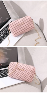 Détail d'un petit sac bandoulière rose brodé avec texture vintage et chaîne dorée