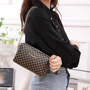 Petit sac bandoulière vintage à pois avec chaîne dorée, porté par un mannequin