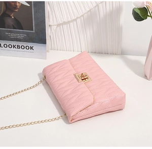 Detail of pink quilted bag with golden rotary metal lock and fine chain strap