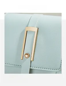 Close-up of light blue pebble leather bag featuring elegant gold metal hardware buckle