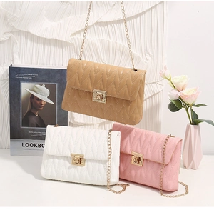Close-up of quilted crossbody bags with gold metal twist locks and chain straps