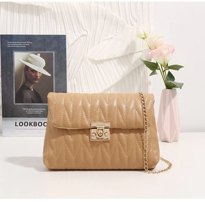 Detail of khaki quilted crossbody bag with gold chain strap and square metal lock