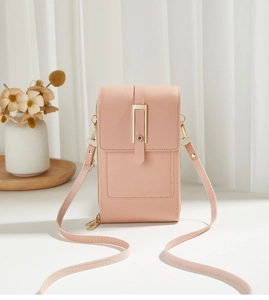 Close-up of a pink crossbody phone bag with gold hardware and fine leather texture