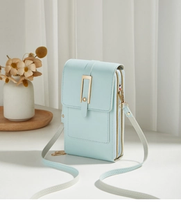 Detail view of mint green phone bag showing double zippers and golden buckle texture