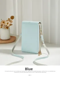 Detail of light blue faux leather crossbody phone bag with double golden zippers