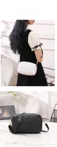 Detail of white and black cross-body bags with V-shaped quilting and gold hardware