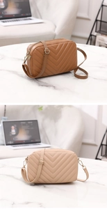 Detail view of V-quilted camera bags in brown and beige with adjustable straps