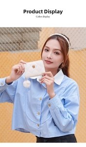 Detail of white quilted leather wallet with gold flower logo and fuzzy pom pom charm
