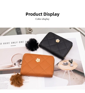 Detailed view of quilted leather wallets featuring golden camellia ornaments and fur ball charms