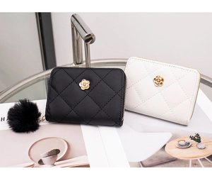 Close-up of quilted card holders with gold flower clasp and plush pom pom detail