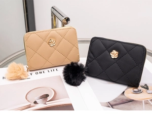 Detailed shot of quilted faux leather wallets with camellia flower decor and pompom