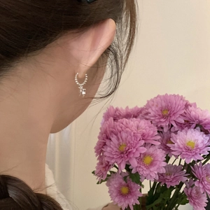 Boucles d'oreilles créoles à billes argentées avec pendentif portées par mannequin
