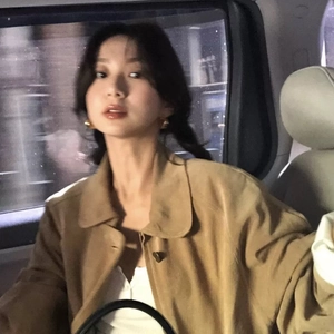 Minimalist vintage gold ball earrings worn with a chic brown suede jacket in city night