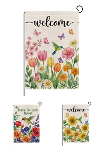 Detailed view of three watercolor garden flags with floral hummingbird designs