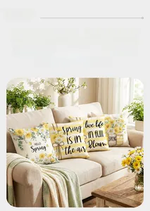Close-up of four spring daisy cushion covers with floral prints and Hello Spring text