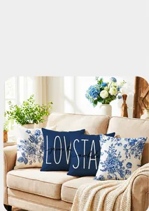 Fundas de cojín estilo porcelana azul con letras LOVE y STAY en un sofá beige