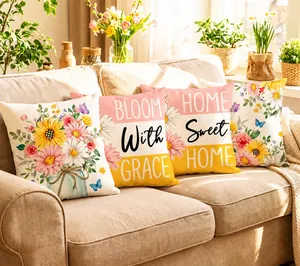 Détail de housses de coussin printanières avec texte Bloom with Grace sur canapé