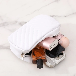 White quilted crossbody bag with wave texture showing large interior capacity on marble