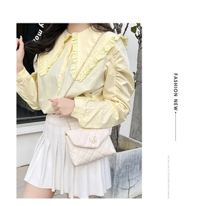Beige Stepptasche mit Metall-Schmetterling und Goldkette an weiblichem Modell
