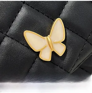 Nahaufnahme der Schmetterlingsschließe an einer schwarzen gesteppten Damenhandtasche