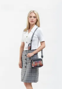 Dettaglio borsa a tracolla color-block con tracolla geometrica e mini portamonete