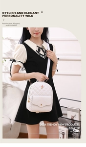 Detail showing white quilted mini backpack with small rose embroidery and gold zippers