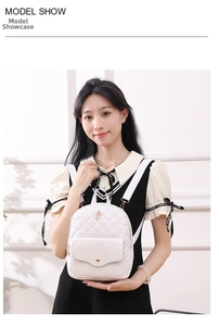 Detail of white quilted mini backpack featuring pink rose embroidery and golden snap button