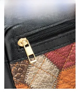 Dettaglio della cerniera metallica personalizzata su borsa in pelle patchwork