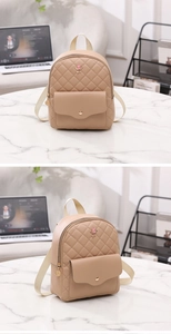 Close-up of beige quilted mini backpack with decorative pink rose metal emblem