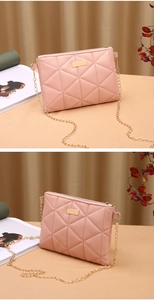 Detailed view of pink quilted faux leather bag with golden chain and metal logo plate