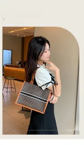 Detail of printed tote bag with orange leather handles and black-white stripe decoration