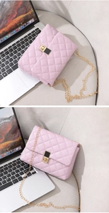 Detail of pink quilted crossbody bag with gold chain strap and metallic twist-lock closure