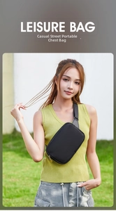Outdoor shot of a minimalist black water-resistant chest bag with golden metal zippers