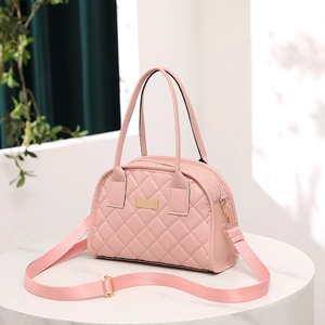 Detail of light pink quilted handbag with gold-tone hardware and adjustable strap